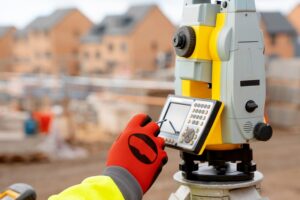 Ingeniero trabajo de construcción de viviendas utilizando equipos topográficos modernos